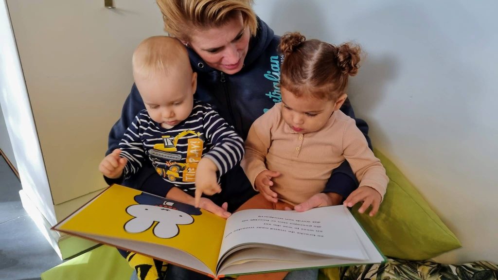 Gastouder-twee-kinderen-aan-het-voorlezen-op-schoot-gastouder zoeken - Welkom Kind